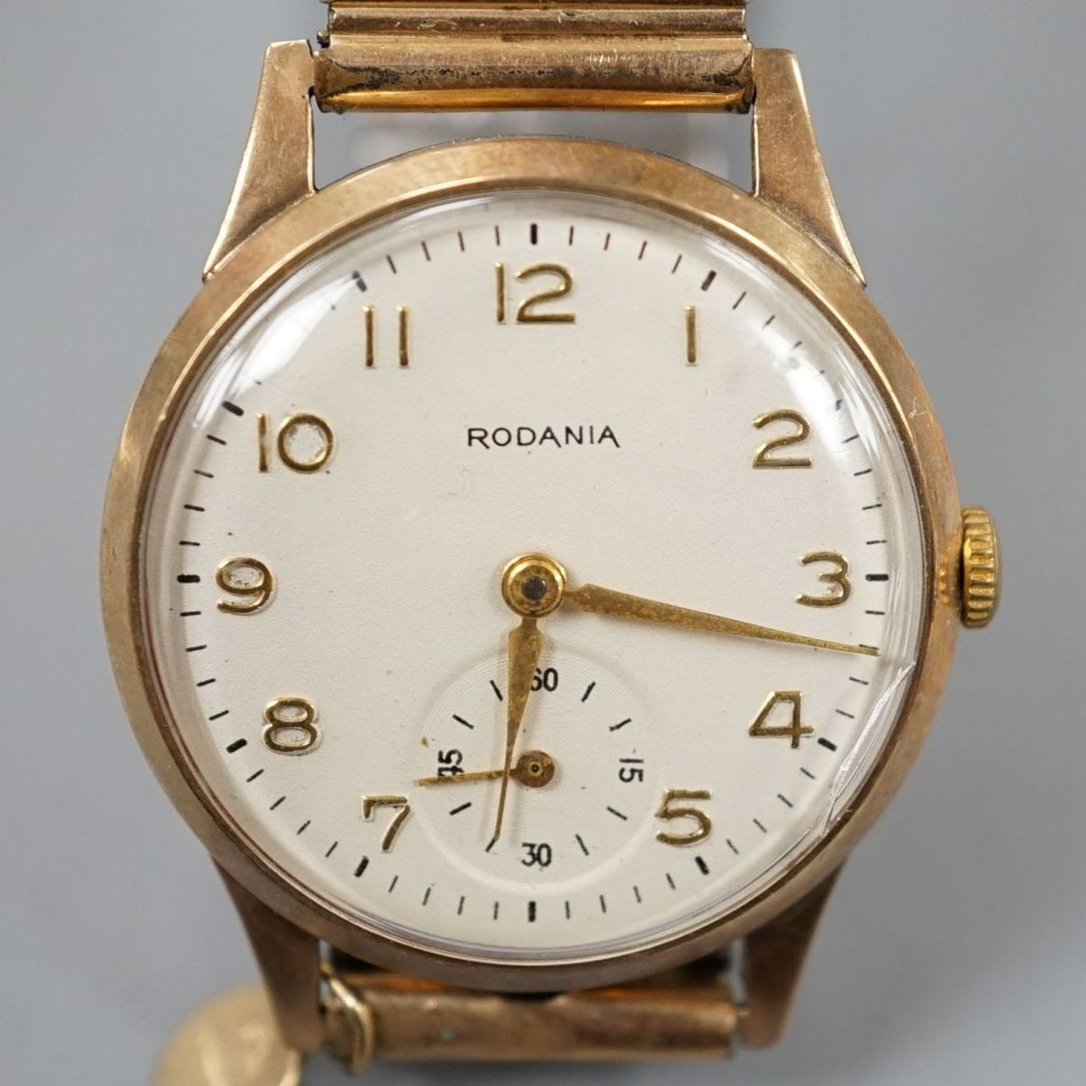 A gentleman's 9ct gold Rodania manual wind mid size wrist watch on associated gold plated expanding bracelet.